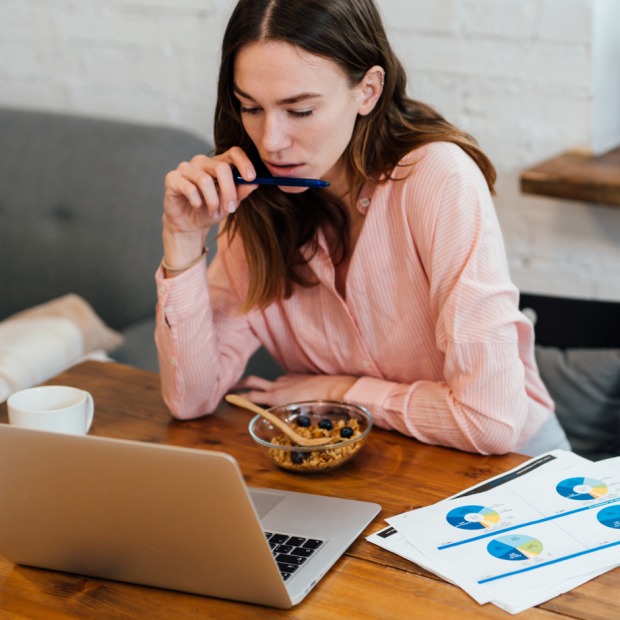 Frau isst vor dem Computer | Credit: iStock.com/undrey