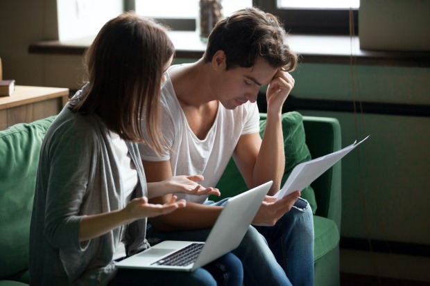 Verzweifeltes junges Paar vor aufgeklappten Laptops