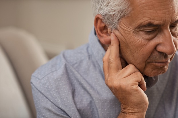 Mann überprüft sein Gehör | Credit: iStock.com/Ridofranz