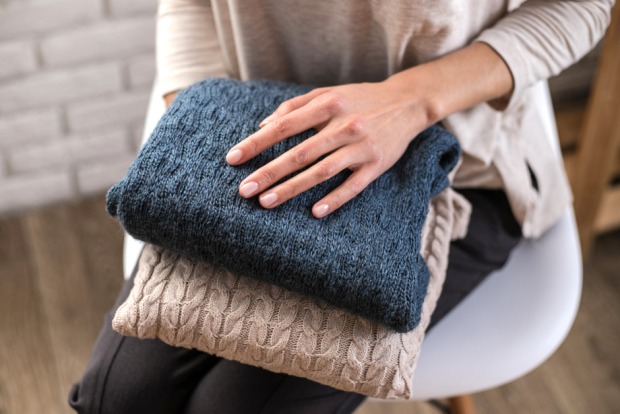 Frau mit Wollpullovern in ihren Händen | Credit: iStock.com/Evgeniia Siiankovskaia