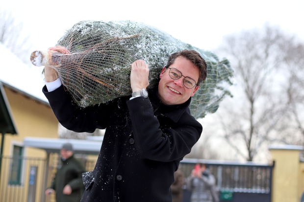Stadtrat Jürgen Czernohorszky trägt einen Christbaum