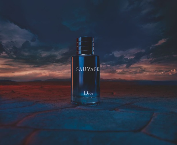 Parfümflakon mit der Aufschrift Sauvage Dior vor düsterem Himmel