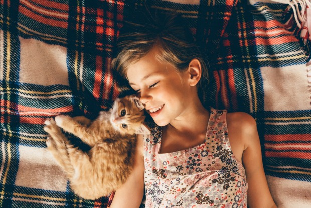 Mädchen kuschelt mit einer Katze