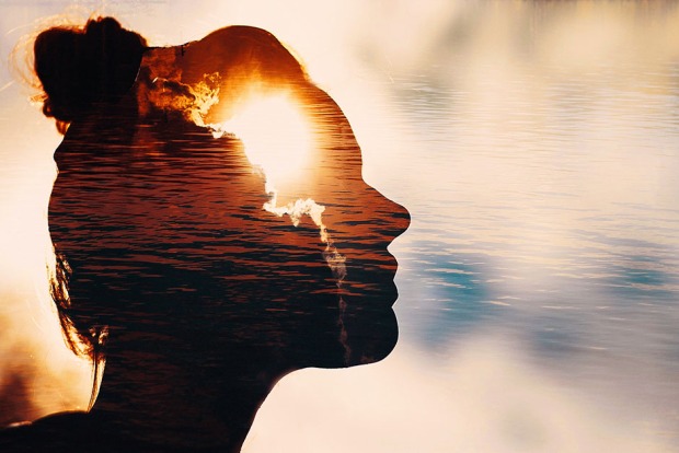 Frau im Sonnenaufgang blickt Richtung Himmel | Credit: iStock.com/primipil