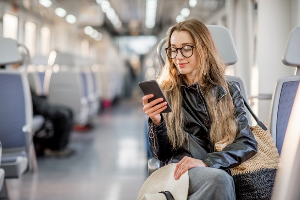 Frau liest am Handy im Zug | Credit: iStock.com/RossHelen