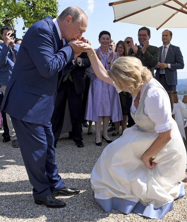 Karin Kneissl knickst im Brautgleid vor Putin, dieser küsst ihr dafür die gereichte Hand.