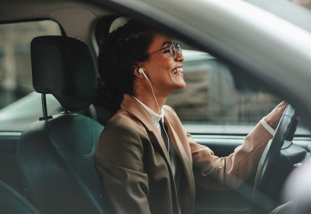 Gut gelaunte Frau telefoniert im Auto über ihre Freisprechanlage | Credit: iStock.com/jacoblund
