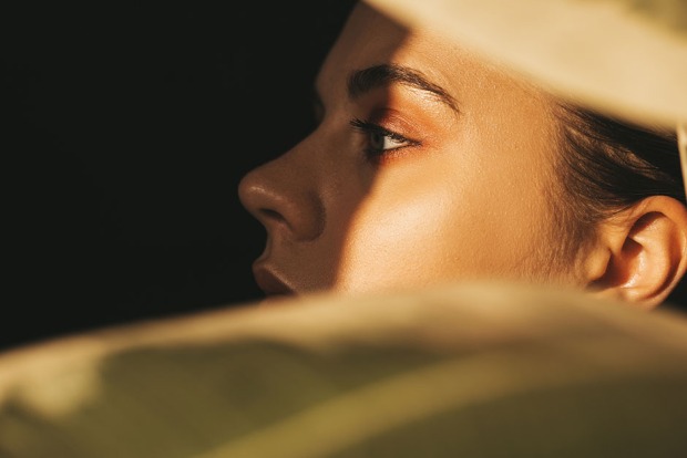Seitenansicht einer jungen Frau mit sonnengebräunter Haut | Credit: iStock.com/SiberianBeauty