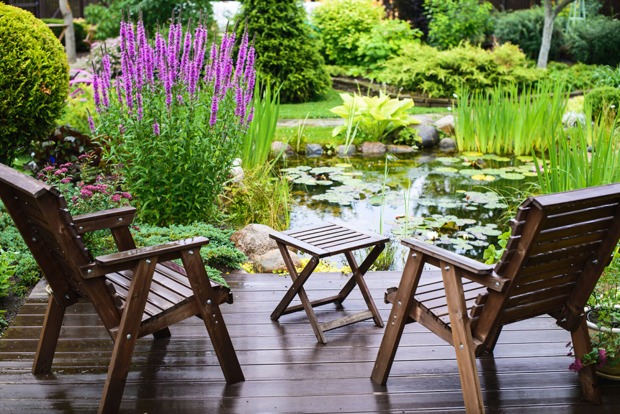 Kleine Holzterrasse mit Blick auf einen Gartenteich | Credit: iStock.com/Nadanka