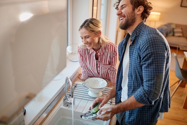 Glückliches Paar bei der gemeinsamen Hausarbeit | Credit: iStock.com/LuckyBusiness