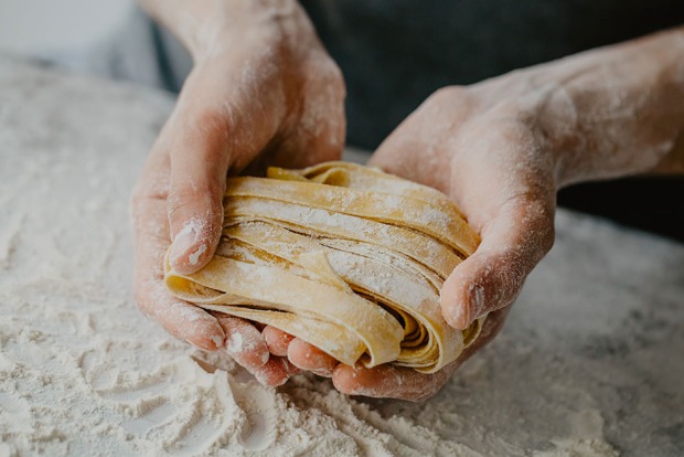 Mann mit fertigem Nudelteig in seinen Händen | Credit: iStock.com/nerudol