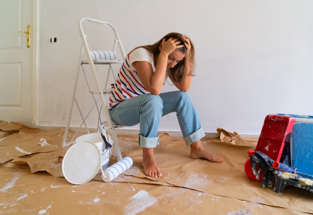 Frau sitzt frustriert unter Farbeimern | Credit: iStock.com/neirfy