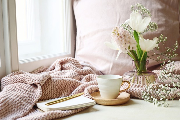 Stilleben aus Kuscheldecke, Teeservice und Blumen in einer Vase | Credit: iStock.com/Tabitazn