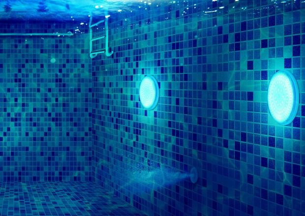 Unterwasseraufnahme eines Pools, der von zwei Leuchtkörpern erhellt wird