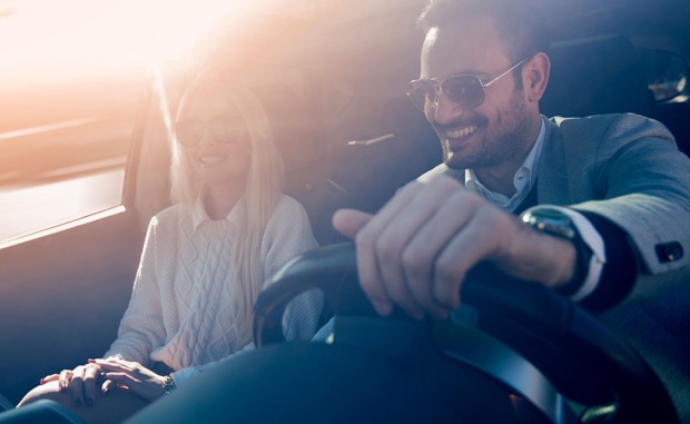 Junges glückliches Paar unterwegs im Auto | Credit: iStock.com/Ivanko_Brnjakovic