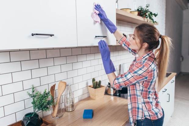 junge Frau putzt Küchenschrank | Credit: iStock.com/undrey