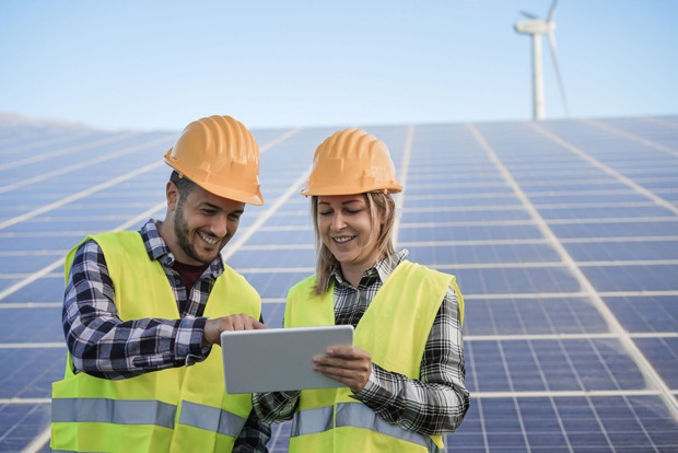 Ein Monteur und eine Monteurin bei der Wartung einer Photovoltaik-Anlage | Credit: iStock.com/DisobeyArt