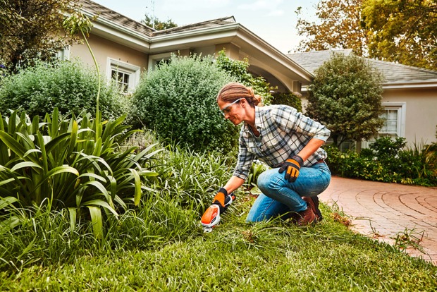 Frau bei der Gartenarbeit mit einer Akku-Grasschere von STIHL in der Hand | Credit: ZGONC