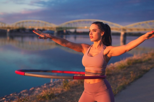 Frau trainiert mit Hula Hopp Reifen | Credit: iStock.com/sakkmesterke
