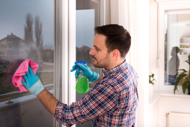 Mann putzt ein Fenster | Credit: iStock.com/Jevtic