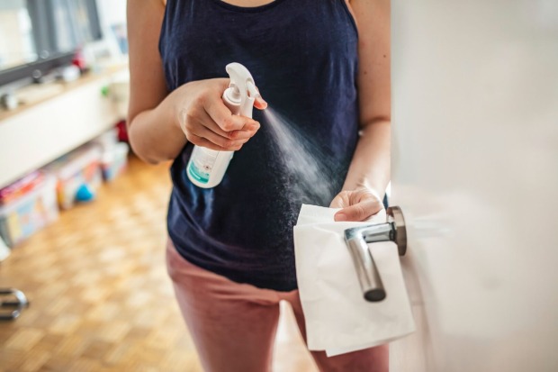 Frau reinigt Türklinke | Credit: iStock.com/dragana991