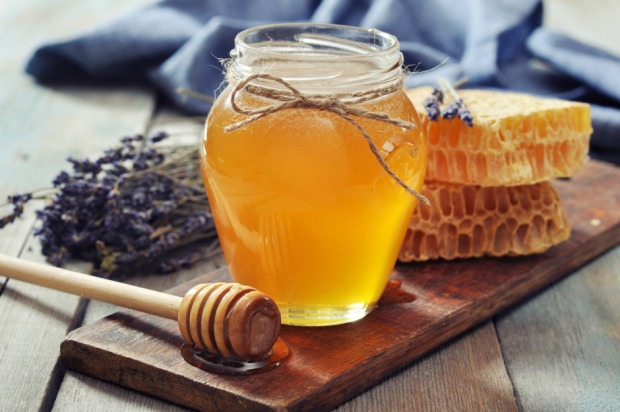 Geöffnetes Honigglas neben Bienenwaben und gebündeltem Lavendel | Credit: iStock.com/tashka2000