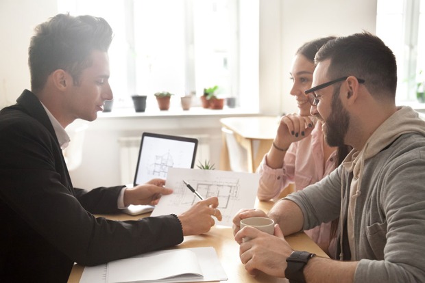 Fachmann berät junges Pärchen in puncto Immobilien | Credit: iStock.com/fizkes