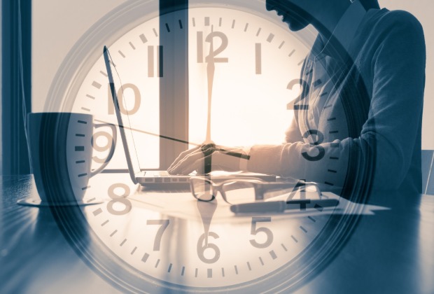 Eine Uhr steht vor einem Laptop | Credit: iStock.com/kieferpix