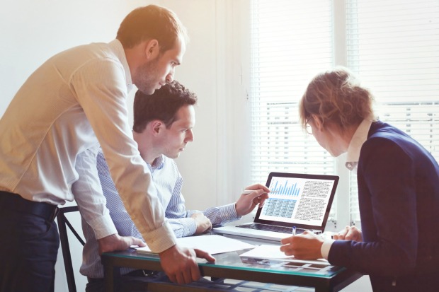 Chef und zwei Mitarbeiter stehen vor einem Laptop | Cedit: iStock.com/anyaberkut