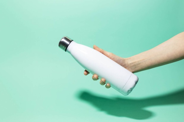 Frau mit Trinkflasche aus Metall in der Hand | Credit: iStock.com/fedcophotogrphy