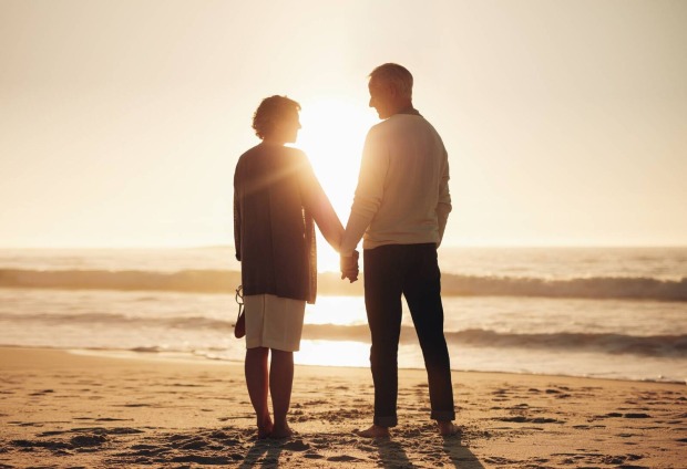 Verliebtes reiferes Paar am Strand bei Sonnenuntergang | Credit: iStock.com/Jacob Ammentorp Lund