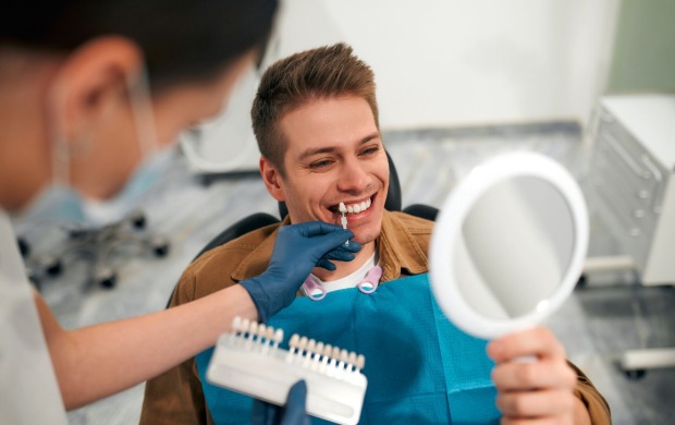 Mann bekommt von Zahnärztin Veneers | Credit: iStock.com/Valerii Apetroaiei