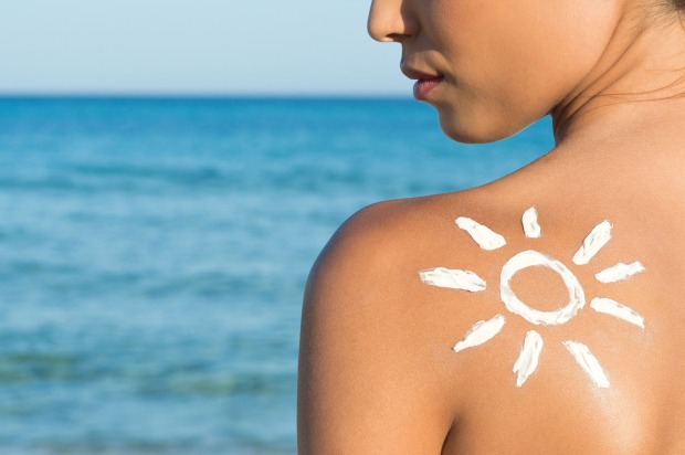 Junge Frau mit einer Sonne aus Sonnencreme auf ihrer Schulter | Credit: iStock.com/Ridofranz