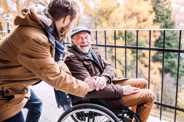 Betreuer mit Mann im Rollstuhl | Credit: iStock.com/Halfpoint