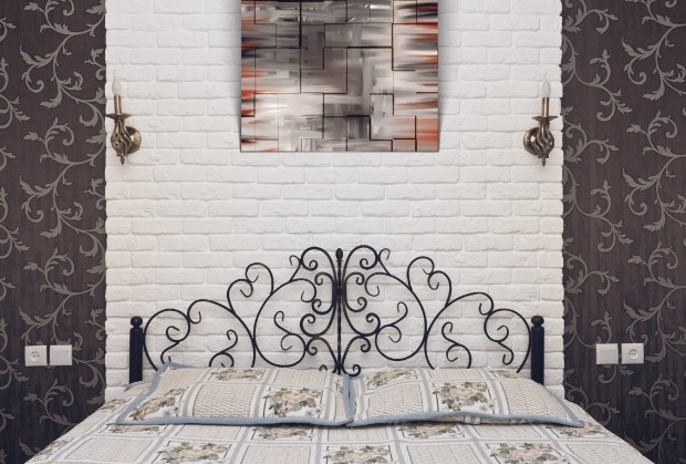 Schwarzes Metallbett steht vor einer hellen Wand | Credit: iStock.com/eranicle