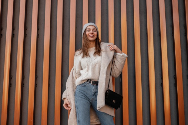 Model steht mit Herbst-Mode vor einer gestreiften Wand | Credit: iStock.com/ Ales_Utovko