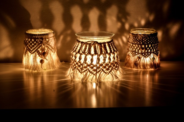 Drei Makramee-Windlichter stehen auf einem Tisch | Credit: iStock.com/janzwolinski