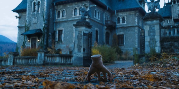 Das eiskalte Händchen steht vor einem Haus | Credit: ©Netflix / Everett Collection / picturedesk.com