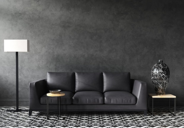Eine schwarze Couch steht vor einer schwarzen Wand | Credit: iStock.com/Artjafara