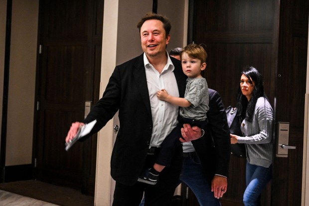 Elon Musk hält X Æ A-XII auf dem Arm.