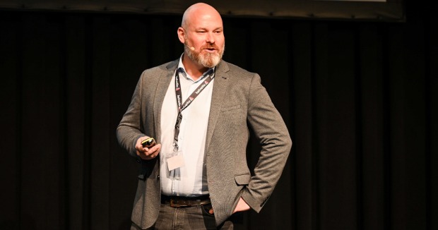 Cyber-Experte Jürgen Weiss mit weißem Hemd vor einer schwarzen Wand | Credit: Christian Dusek/Helvetia