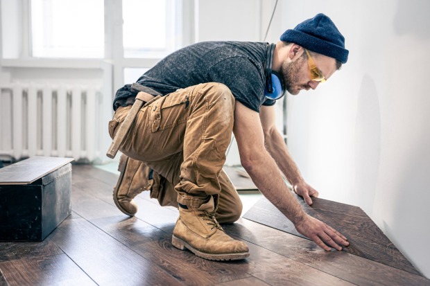 Mann arbeitet am Parkett-Boden | Credit: iStock.com/puhimec