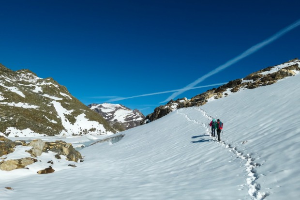 Zwei Skitourengeher auf einem verschneiten Berg | Credit: iStock.com/Christopher Moswitzer