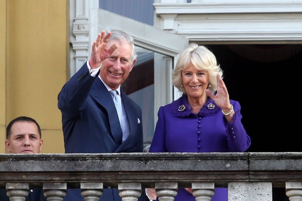 Charles und Camilla winken vom Balkon.