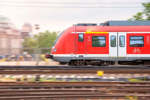 Elektrischer Nahverkehrszug, der in einen Bahnhof einfährt.