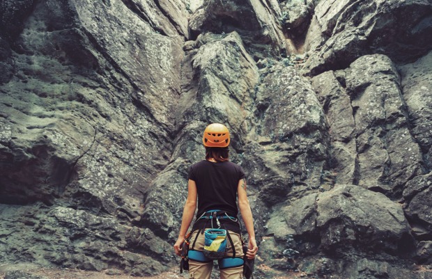 Frau steht vor einer Felswand | Credit: iStock.com/Remains