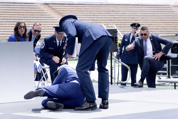 Joe Biden stürzt auf einer Bühne.