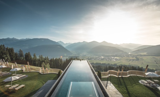vorne ragt der Infinitypool ins Bild, dahinter ist die Südtiroler Bergwelt zu sehen