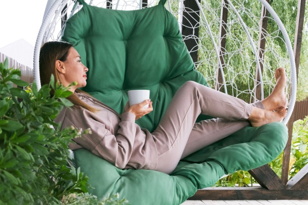 Frau sitzt im Sessel und trinkt Kaffee | Credit: iStock.com/Irina Zharkova