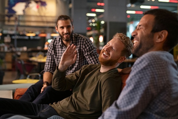 Männer sitzen zusammen und lachen | Credit: iStock.com/Ridofranz